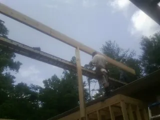 Carpenter setting a ridge beam over a new addition frame — Ice Dam Removal by Roofing Brothers in Remsenburg