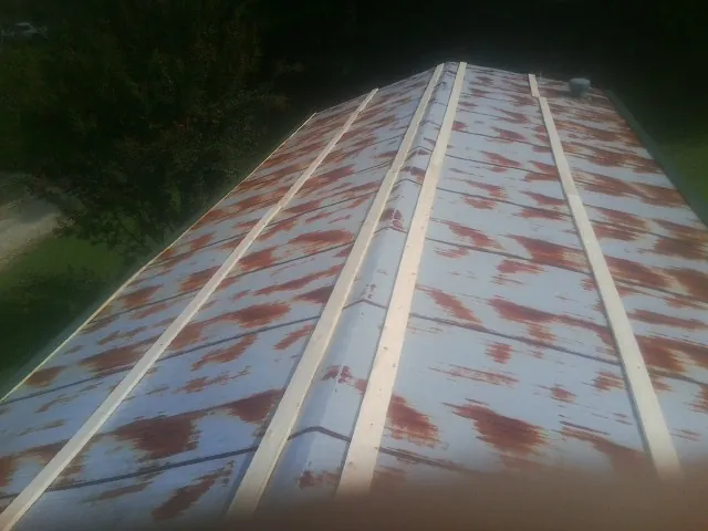 Rusted metal roof panels with new wood purlins before replacement — Storm Damage Roof Repair in Remsenburg by Roofing Brothers